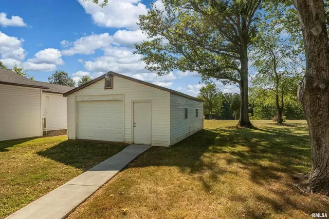 a view of a house with backyard and trees