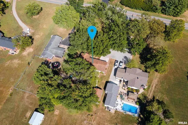 an aerial view of a house with a yard and lake view