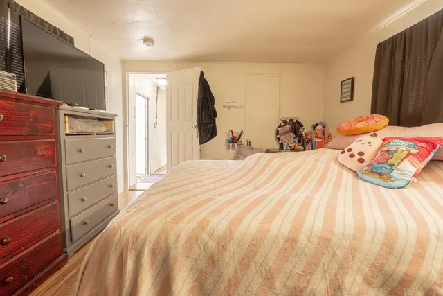 a bedroom with a bed and a flat tv screen