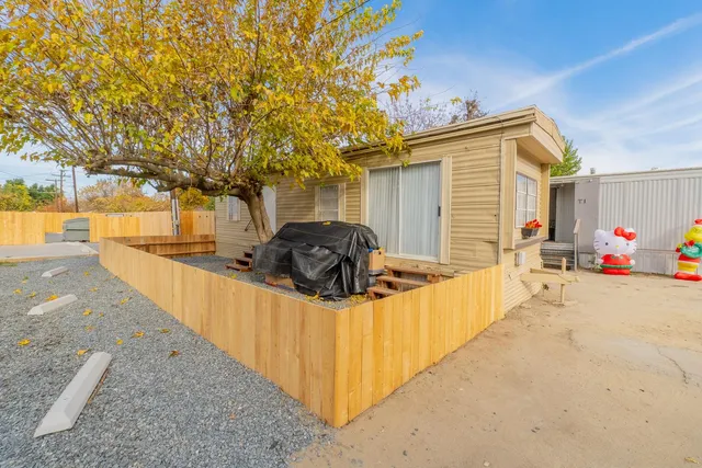 a front view of a house with a garden and trees