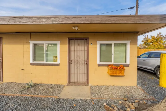a front view of a house with a tree