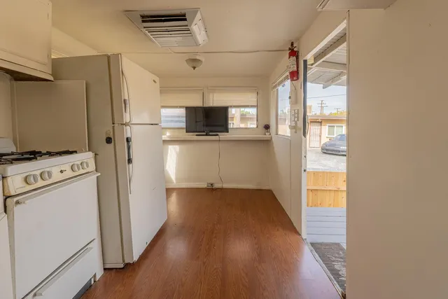 a kitchen with a refrigerator a stove top oven a sink and a window