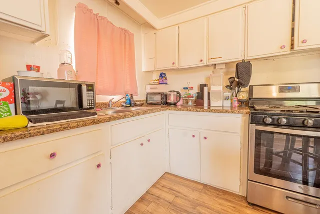 a kitchen with stainless steel appliances granite countertop a sink a stove and cabinets