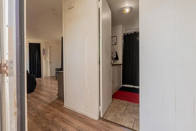 a view of a hallway with wooden floor and closet