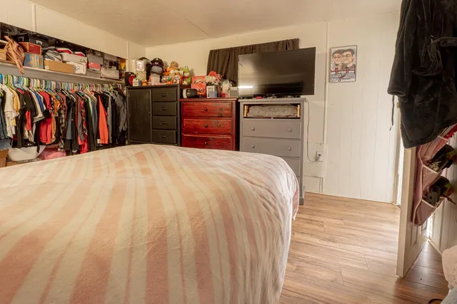 a bedroom with a bed and a flat screen tv