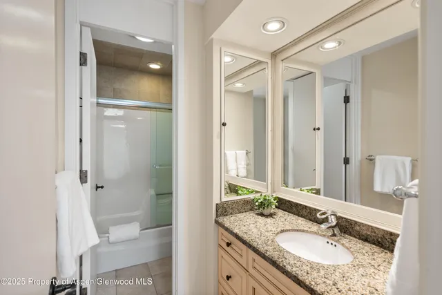a bathroom with a granite countertop sink shower and a mirror