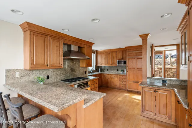 a kitchen with stainless steel appliances granite countertop a sink stove and cabinets