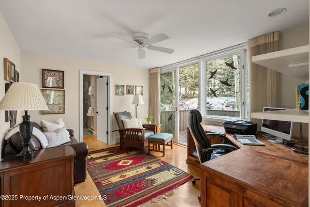 a living room with furniture a flat screen tv and a floor to ceiling window