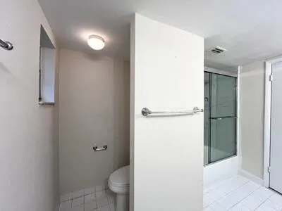 a bathroom with a granite countertop shower and a toilet