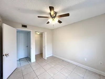 a view of an empty room and chandelier fan