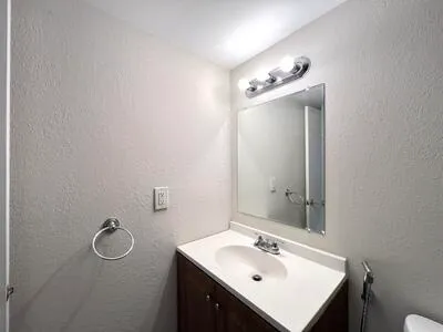 a bathroom with a sink vanity and mirror