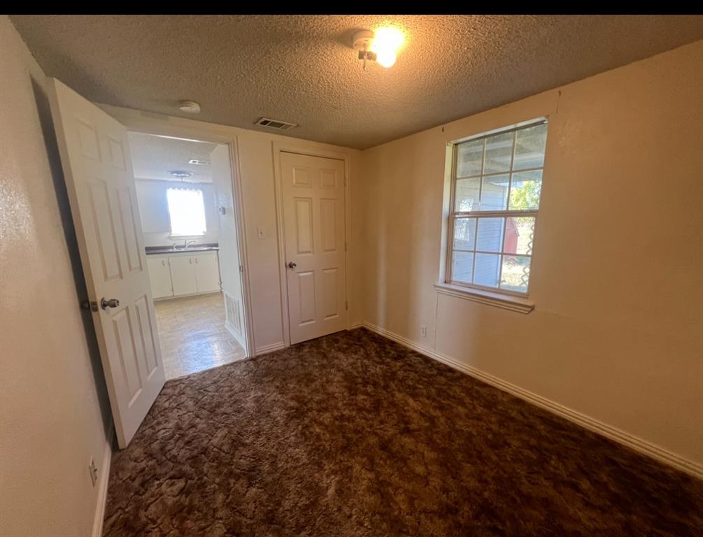 3133 Tbd County Road Lone Oak, TX 75453 - Photo 6 of 21 Interior room featuring textured brown carpet, light-toned wall paint, and a window with white trim