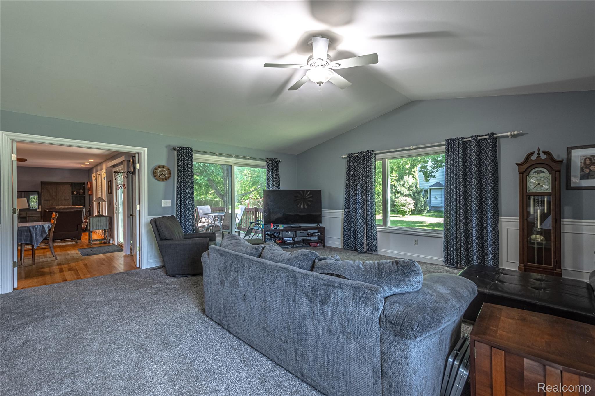 3241 Simpson Road Fort Gratiot, MI 48059 - Photo 17 of 27 Vaulted ceiling living room featuring a ceiling fan, wall-to-wall carpeting, and a sliding glass door