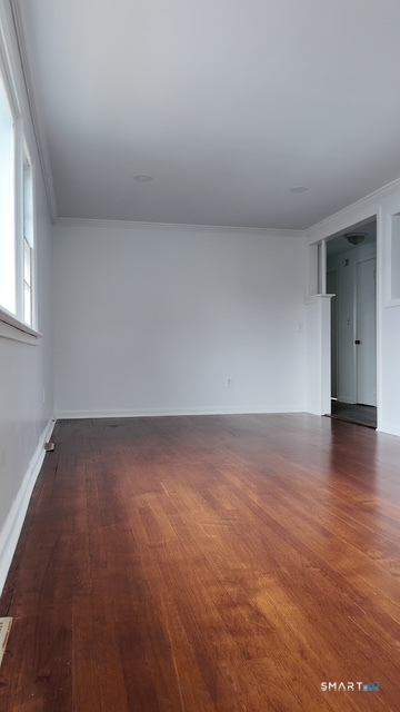 131 Ruth Street Bridgeport, CT 06606 - Photo 23 of 31 an empty room with wooden floor and windows
