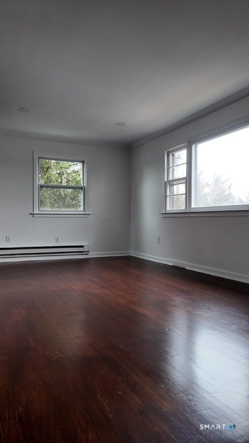 131 Ruth Street Bridgeport, CT 06606 - Photo 25 of 31 an empty room with wooden floor and windows