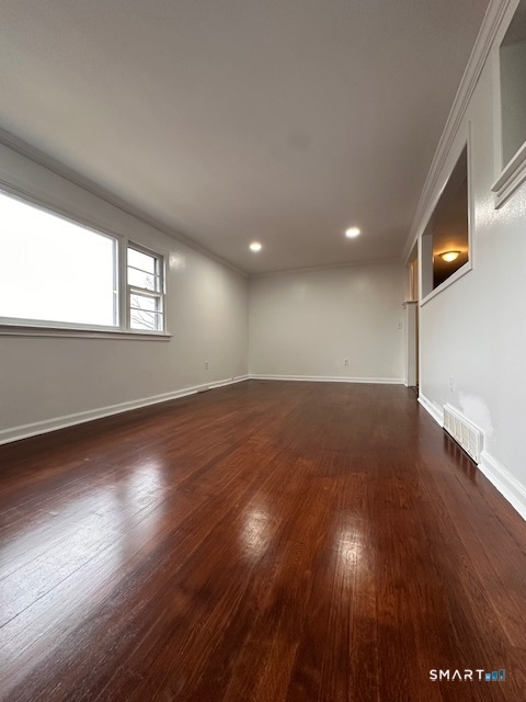 131 Ruth Street Bridgeport, CT 06606 - Photo 27 of 31 an empty room with wooden floor and windows