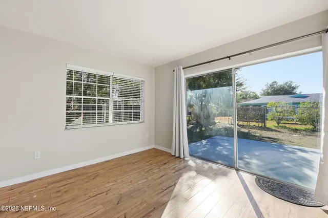 a view of a big room with wooden floor and windows