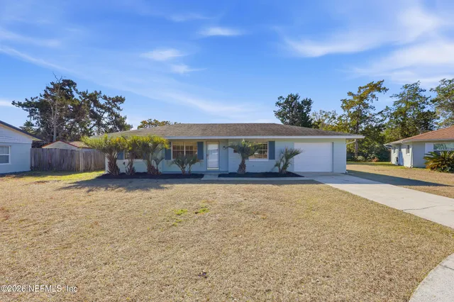 a front view of a house with a yard and trees