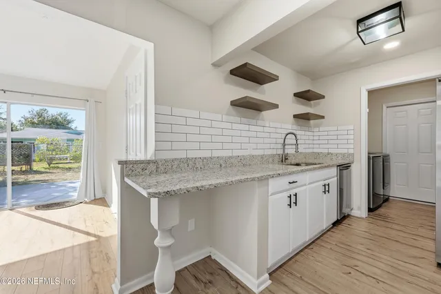 a spacious bathroom with a granite countertop sink a toilet and a large mirror