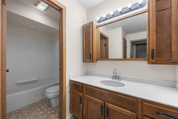 a bathroom with a sink a toilet a shower and a mirror
