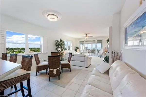 a kitchen with granite countertop a table chairs microwave and cabinets