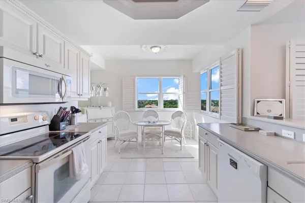 a large white kitchen with a large window
