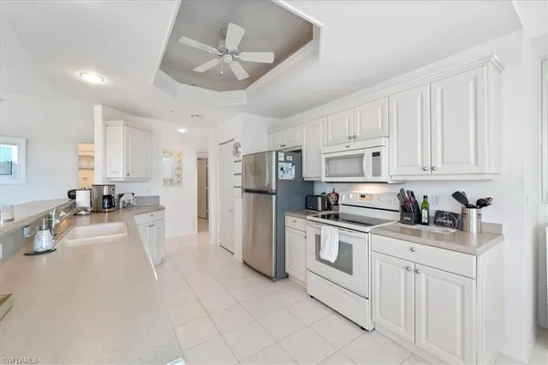 a kitchen with a white cabinets and chairs
