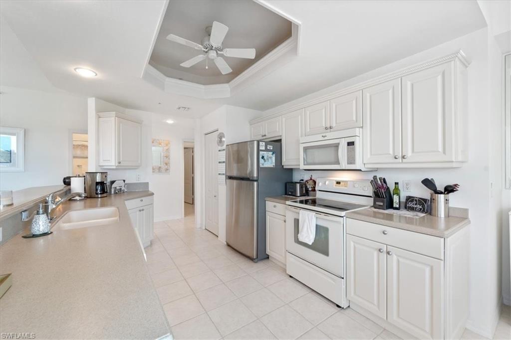 14819 Laguna Drive, Unit 501 Fort Myers, FL 33908 - Photo 18 of 48 a kitchen with white cabinets and stainless steel appliances