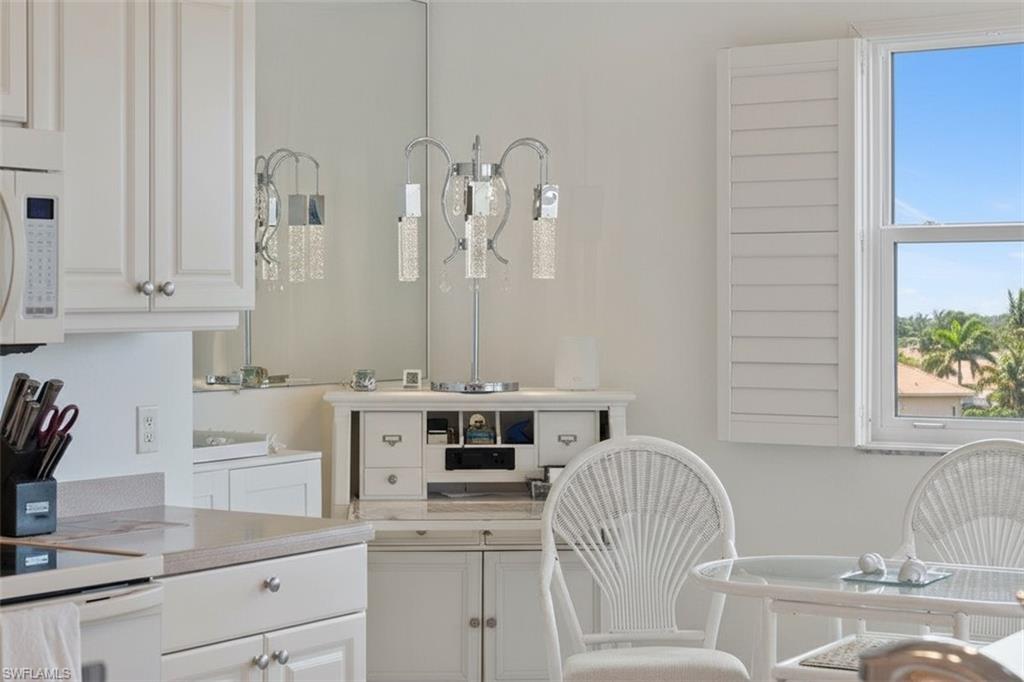 14819 Laguna Drive, Unit 501 Fort Myers, FL 33908 - Photo 19 of 48 a kitchen with a white cabinets and chairs