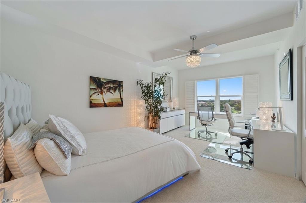 14819 Laguna Drive, Unit 501 Fort Myers, FL 33908 - Photo 22 of 48 a bedroom with a bed and a chandelier