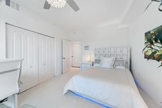 a bedroom with a bed lamp and a potted plant