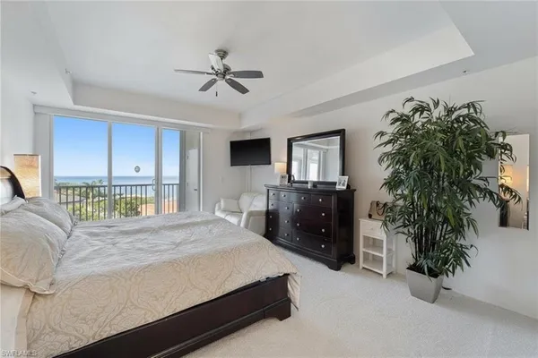 a bedroom with a bed a couch and a ceiling fan
