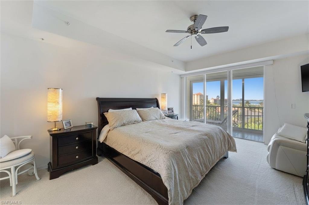 14819 Laguna Drive, Unit 501 Fort Myers, FL 33908 - Photo 26 of 48 a bedroom with a bed a couch and a ceiling fan