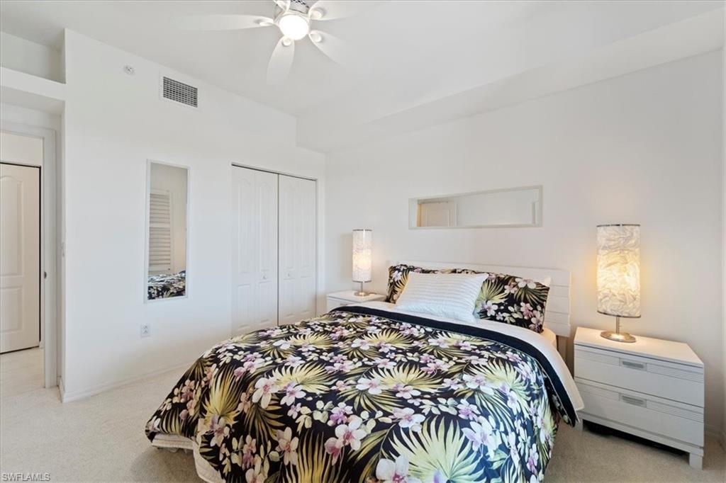 14819 Laguna Drive, Unit 501 Fort Myers, FL 33908 - Photo 34 of 48 a bedroom with a bed and a chandelier