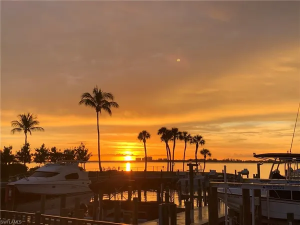 a view of a ocean with boats and palm trees