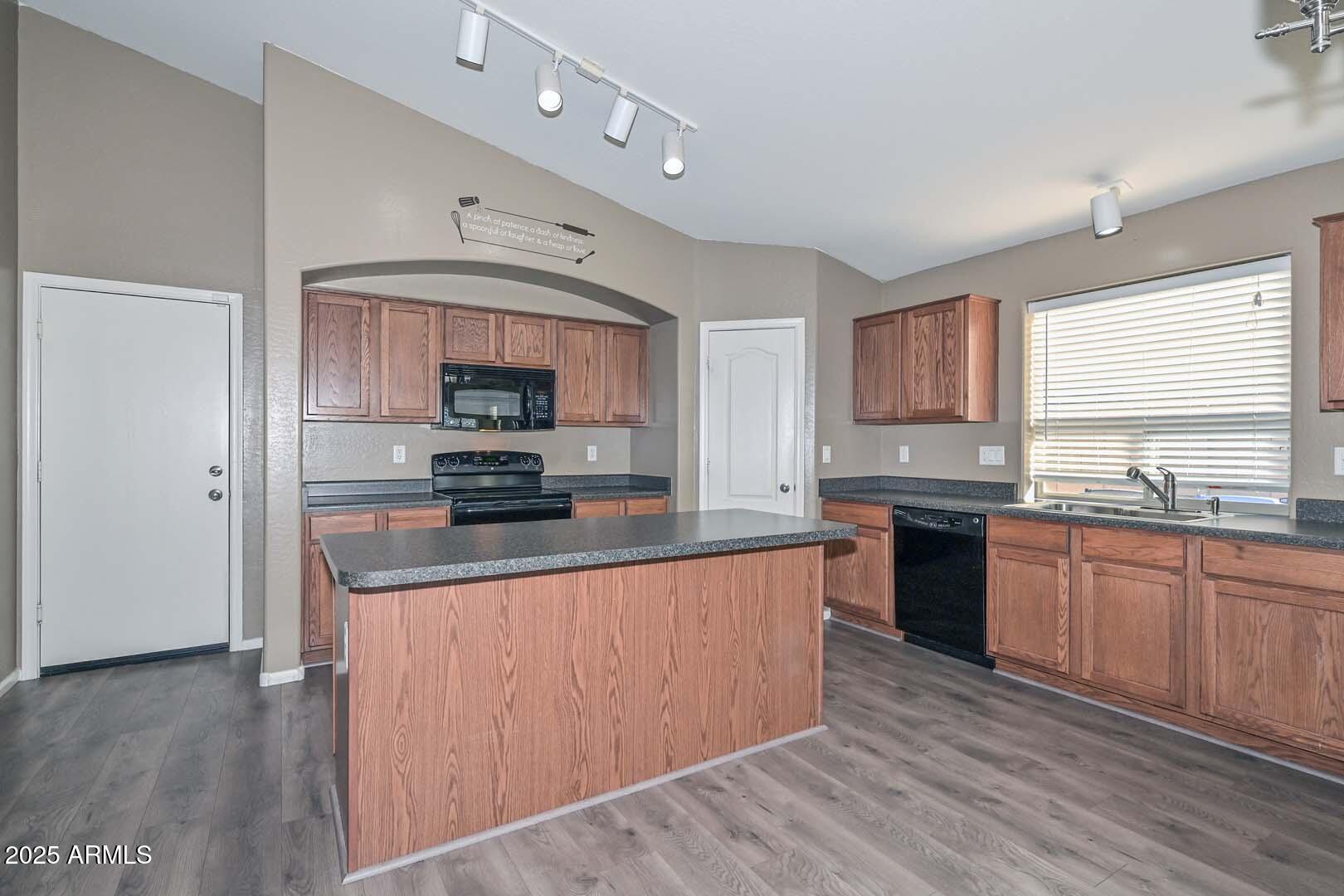 17687 West Charter Oak Road Surprise, AZ 85388 - Photo 11 of 52 a kitchen with stainless steel appliances granite countertop a stove top oven a sink dishwasher and a microwave oven on the wooden floor