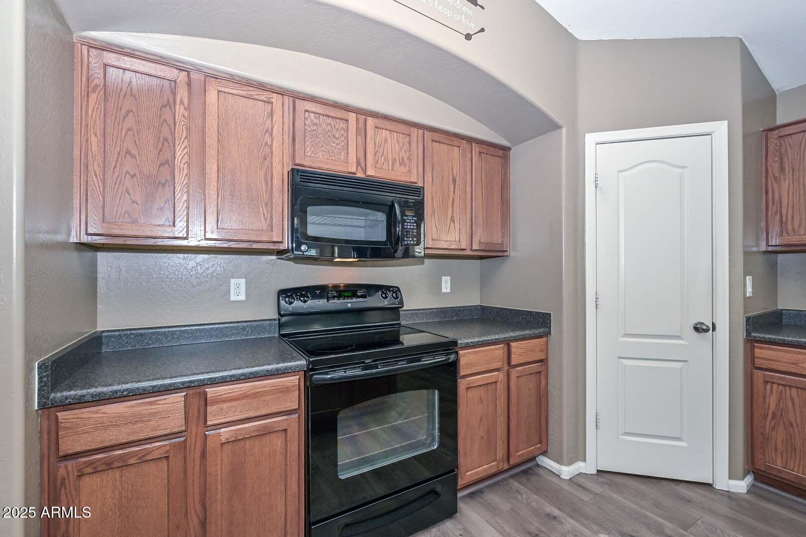 17687 West Charter Oak Road Surprise, AZ 85388 - Photo 12 of 52 a kitchen with granite countertop a stove microwave and cabinets