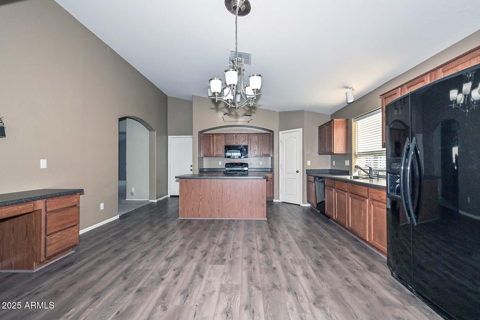 17687 West Charter Oak Road Surprise, AZ 85388 - Photo 13 of 52 a large kitchen with stainless steel appliances granite countertop a lot of counter space and wooden floors