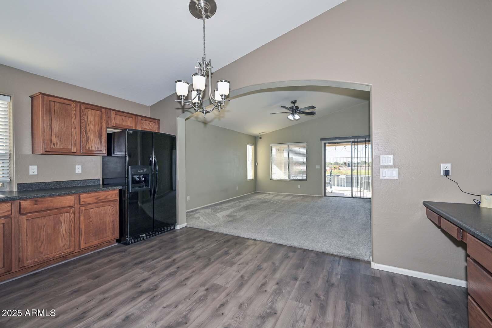 17687 West Charter Oak Road Surprise, AZ 85388 - Photo 14 of 52 a open kitchen with stainless steel appliances granite countertop a refrigerator a sink dishwasher a stove and white countertops with wooden floor