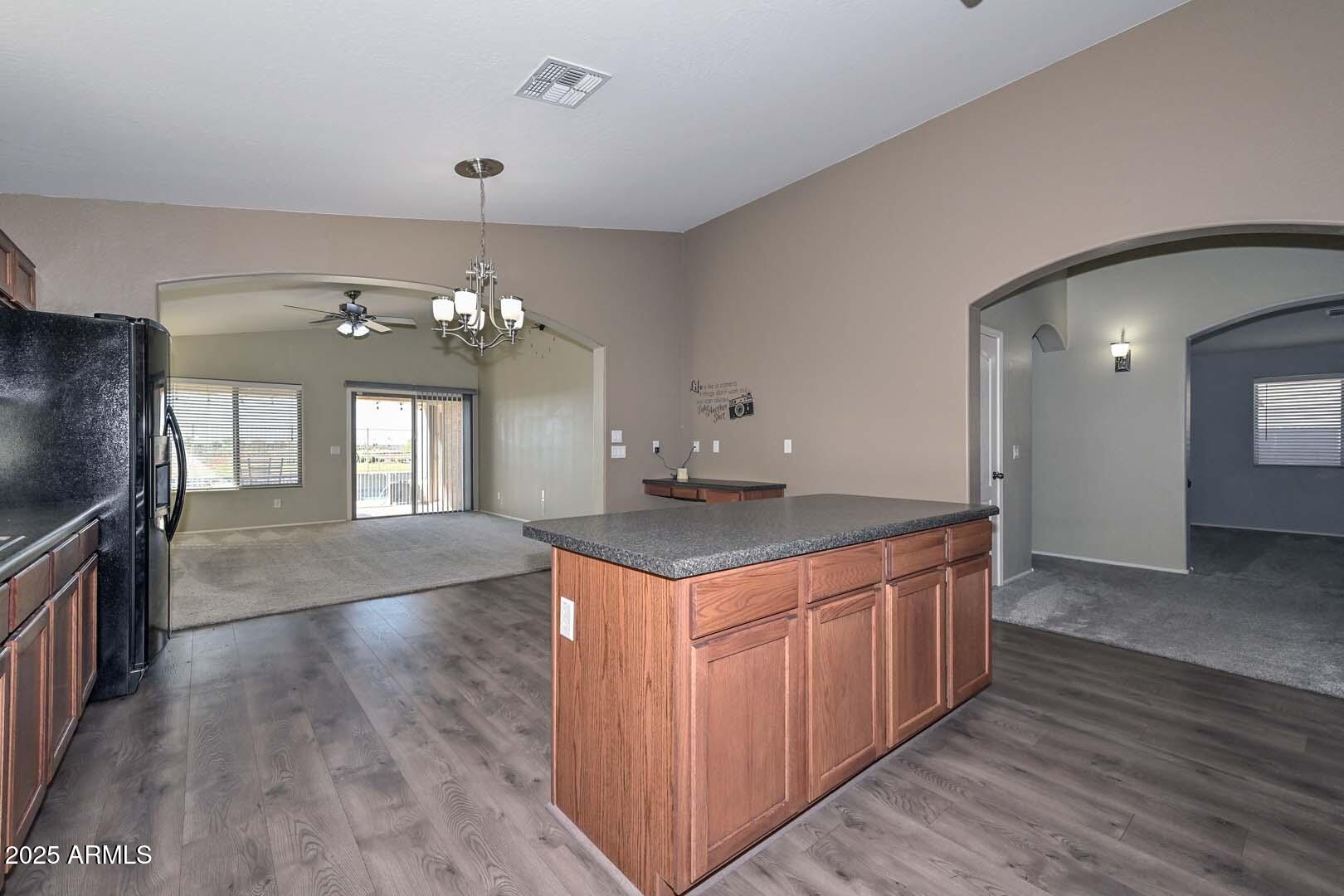 17687 West Charter Oak Road Surprise, AZ 85388 - Photo 15 of 52 a kitchen that has a lot of cabinets and wooden floor