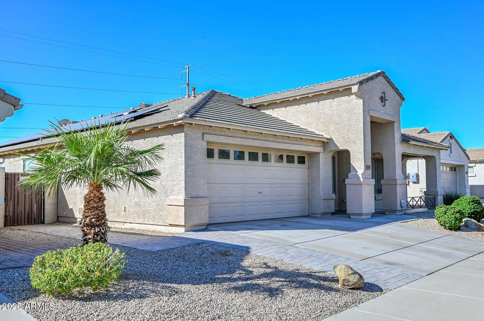 17687 West Charter Oak Road Surprise, AZ 85388 - Photo 3 of 52 a front view of a house with garden