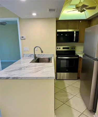 a kitchen with stainless steel appliances granite countertop a sink a stove and a microwave