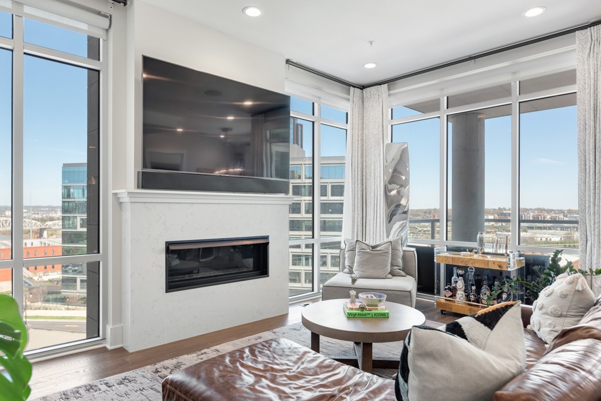 20 Rutledge Street, Unit 407 Nashville, TN 37210 - Photo 11 of 56 a living room with furniture a fireplace and a floor to ceiling window