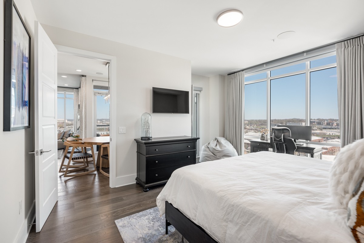 20 Rutledge Street, Unit 407 Nashville, TN 37210 - Photo 21 of 56 a large bedroom with a bed and a flat tv screen on dresser