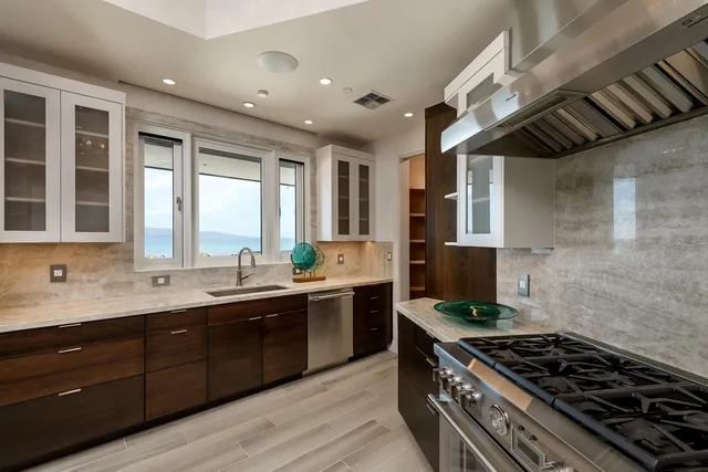 a kitchen with stainless steel appliances a sink stove and cabinets