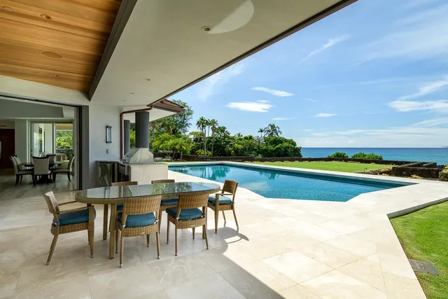 a view of a patio with dining table and chairs under an umbrella