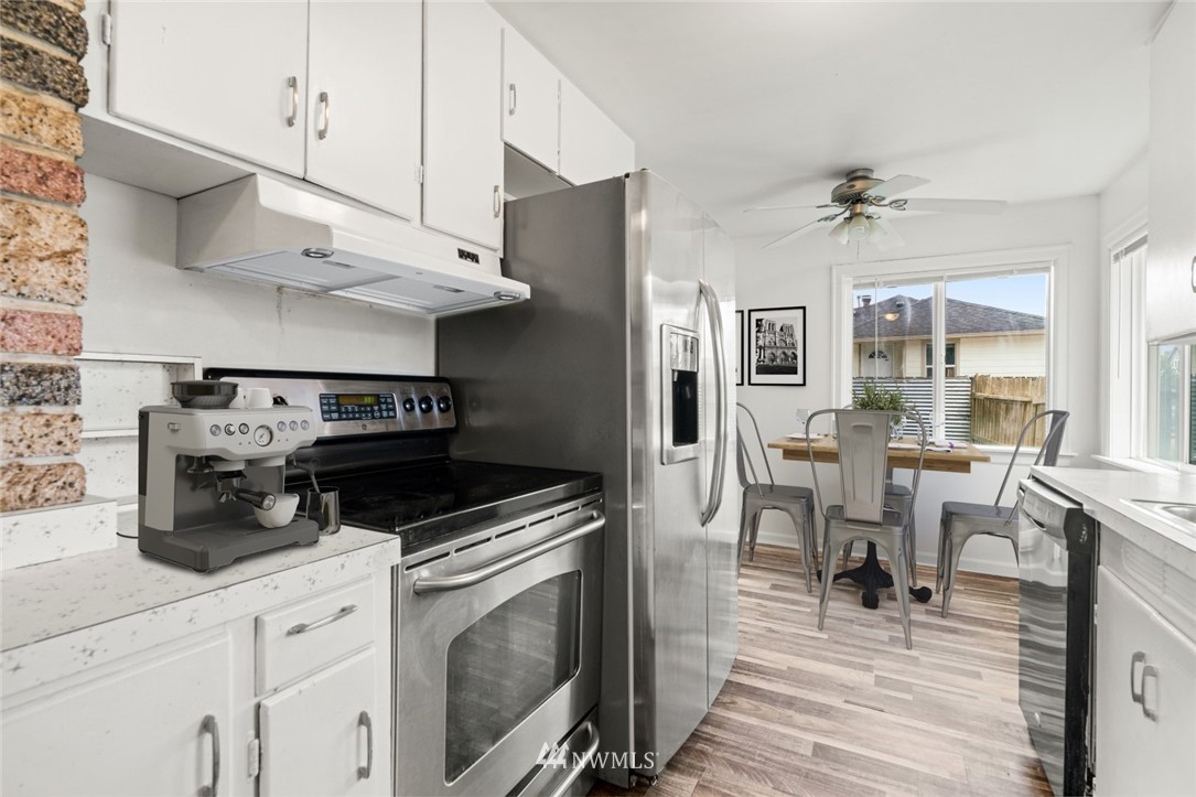 5308 Northeast 4th Street Renton, WA 98059 - Photo 9 of 27 a kitchen with stainless steel appliances a stove a sink cabinets and wooden floor