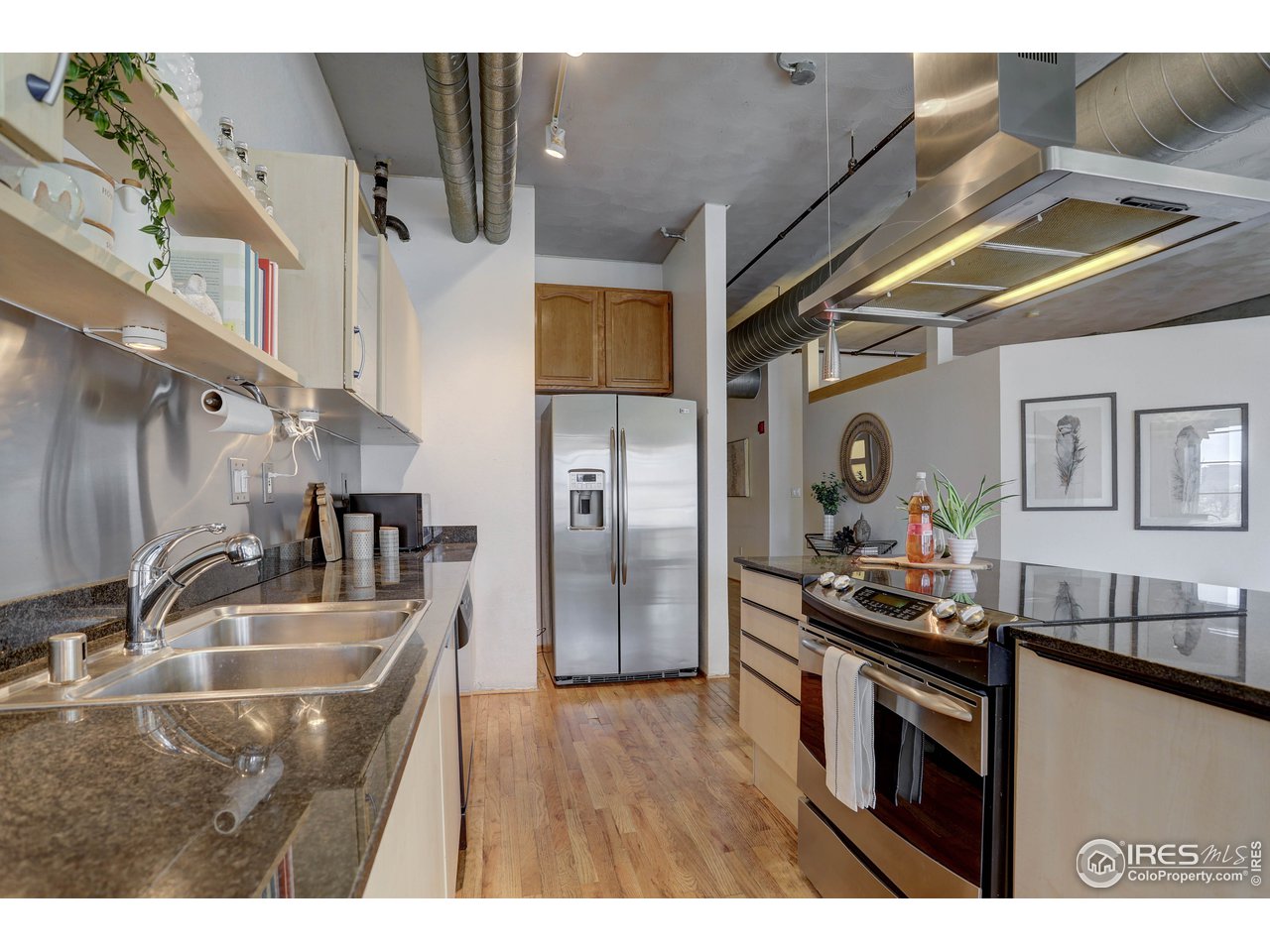 1499 Blake Street, Unit 6G Denver, CO 80202 - Photo 13 of 37 a kitchen with stainless steel appliances granite countertop a sink a stove and refrigerator