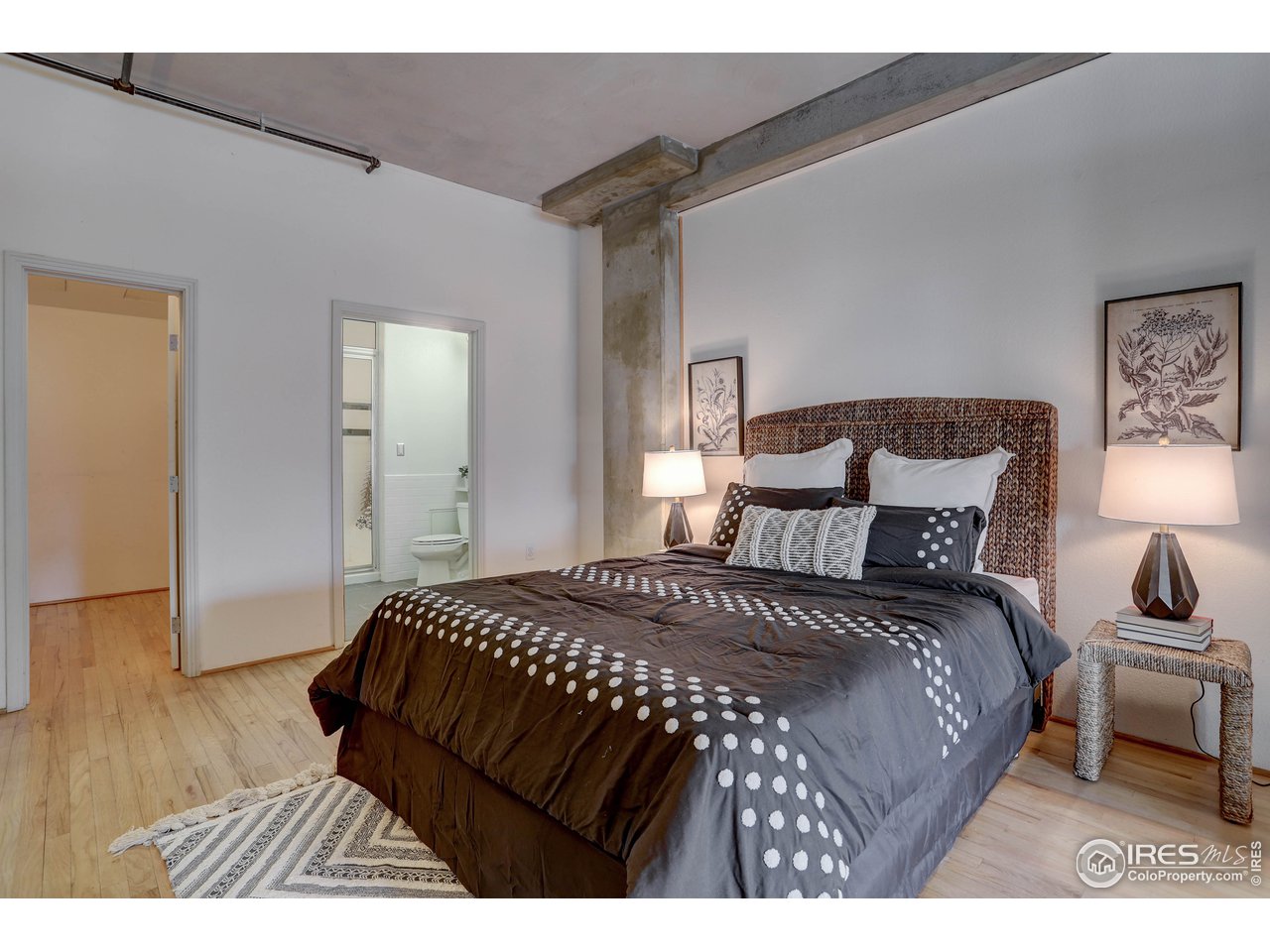 1499 Blake Street, Unit 6G Denver, CO 80202 - Photo 22 of 37 a bedroom with a bed window and a wooden floor