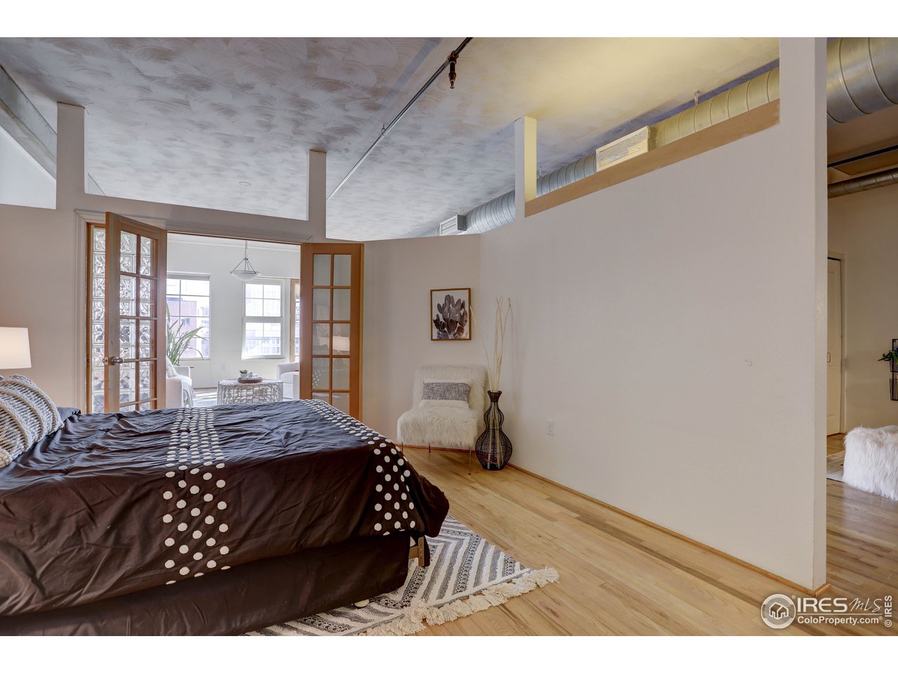 1499 Blake Street, Unit 6G Denver, CO 80202 - Photo 24 of 37 a bedroom with a bed next to a window with a chair